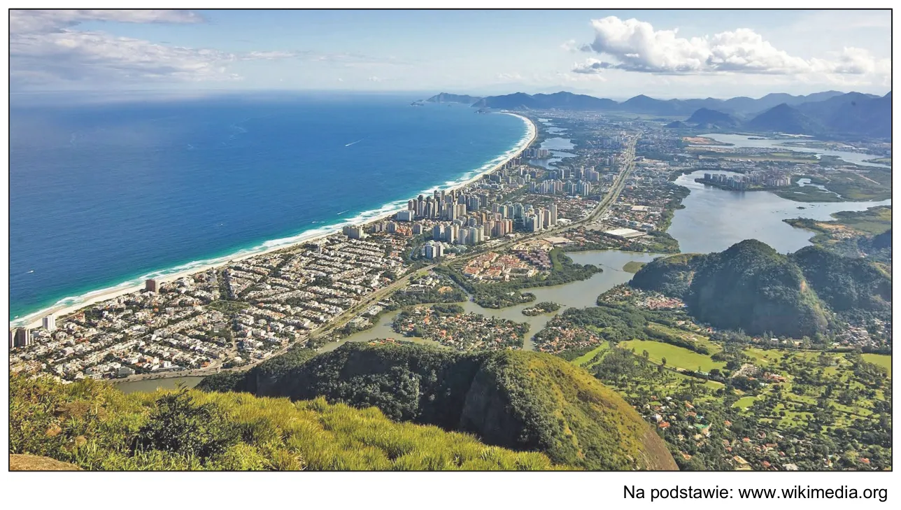 Fotografia fragmentu Rio de Janeiro i okolic z wybrzeżem oceanu, lagunami, zabudową i zalesionymi wzgórzami.