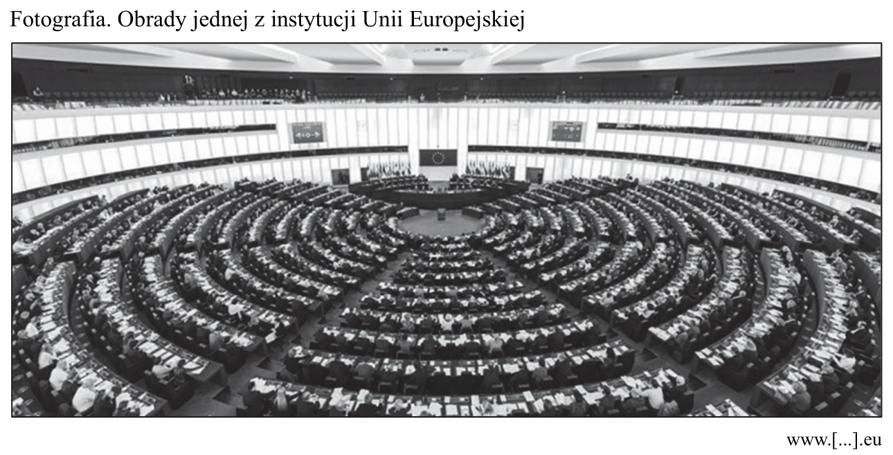 Fotografia sali obrad w kształcie półkola z wieloma rzędami miejsc, w której obraduje jedna z instytucji Unii Europejskiej.